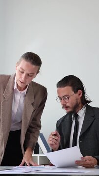 Professional business colleagues brainstorming and collaborating on project documents in a modern office meeting