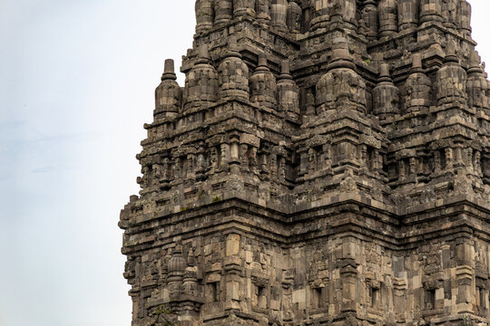 Prambanan Temple in Central Java, Indonesia. A vast 9th-century Hindu temple complex with intricate stone spires, sculptures, and ancient ruins under a cloudy sky.