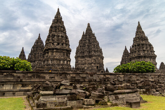 Prambanan Temple in Central Java, Indonesia. A vast 9th-century Hindu temple complex with intricate stone spires, sculptures, and ancient ruins under a cloudy sky.