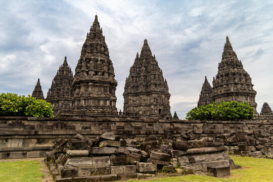 Prambanan Temple in Central Java, Indonesia. A vast 9th-century Hindu temple complex with intricate stone spires, sculptures, and ancient ruins under a cloudy sky.