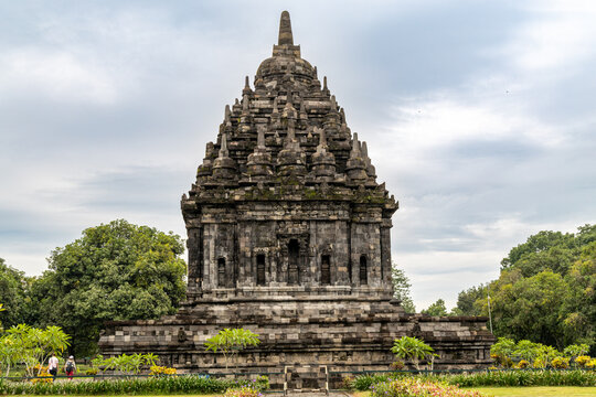 Prambanan Temple in Central Java, Indonesia. A vast 9th-century Hindu temple complex with intricate stone spires, sculptures, and ancient ruins under a cloudy sky.
