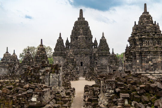 Prambanan Temple in Central Java, Indonesia. A vast 9th-century Hindu temple complex with intricate stone spires, sculptures, and ancient ruins under a cloudy sky.