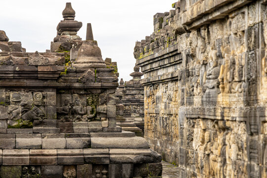 Ancient stone stupas of Borobudur, a UNESCO World Heritage Buddhist monument in Central Java, Indonesia, under an overcast sky.