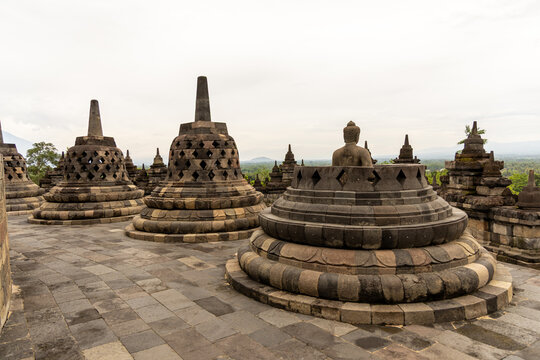 Ancient stone stupas of Borobudur, a UNESCO World Heritage Buddhist monument in Central Java, Indonesia, under an overcast sky.