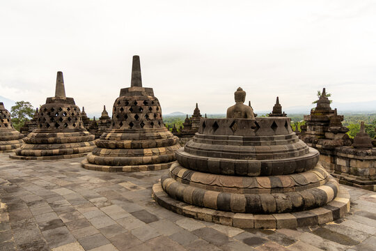 Ancient stone stupas of Borobudur, a UNESCO World Heritage Buddhist monument in Central Java, Indonesia, under an overcast sky.
