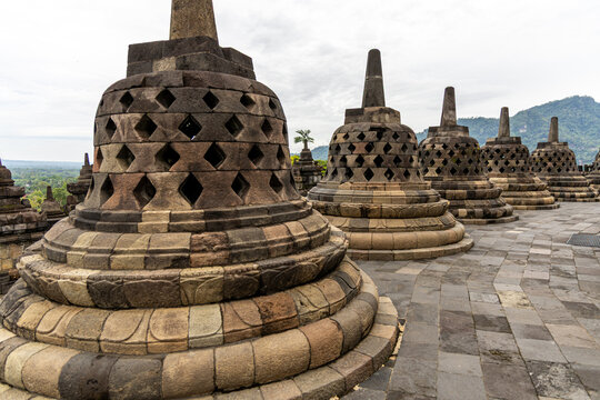 Ancient stone stupas of Borobudur, a UNESCO World Heritage Buddhist monument in Central Java, Indonesia, under an overcast sky.