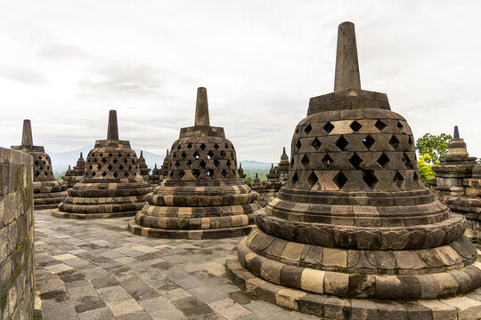 Ancient stone stupas of Borobudur, a UNESCO World Heritage Buddhist monument in Central Java, Indonesia, under an overcast sky.
