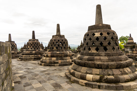 Ancient stone stupas of Borobudur, a UNESCO World Heritage Buddhist monument in Central Java, Indonesia, under an overcast sky.