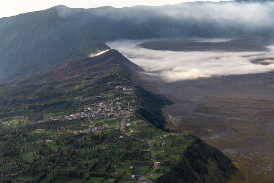 Mount Bromo volcano at sunrise, viewed from King Kong viewpoint in Bromo Tengger Semeru National Park, East Java, Indonesia. Active crater smoke, Mount Semeru cone, clouds, and vast ash plain.