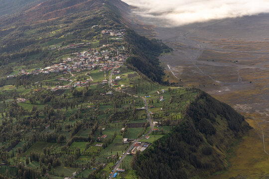 Mount Bromo volcano at sunrise, viewed from King Kong viewpoint in Bromo Tengger Semeru National Park, East Java, Indonesia. Active crater smoke, Mount Semeru cone, clouds, and vast ash plain.