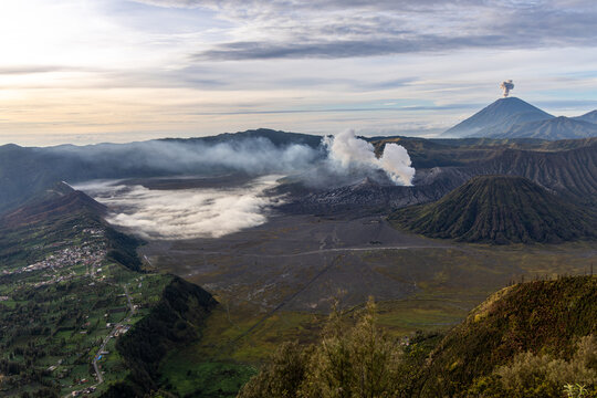 Mount Bromo volcano at sunrise, viewed from King Kong viewpoint in Bromo Tengger Semeru National Park, East Java, Indonesia. Active crater smoke, Mount Semeru cone, clouds, and vast ash plain.