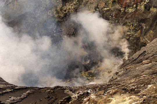 Active Mount Bromo volcano crater with sulfur smoke and volcanic sand sea, Tengger Semeru National Park, East Java, Indonesia.