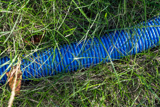 Blue pipe lies on grass
