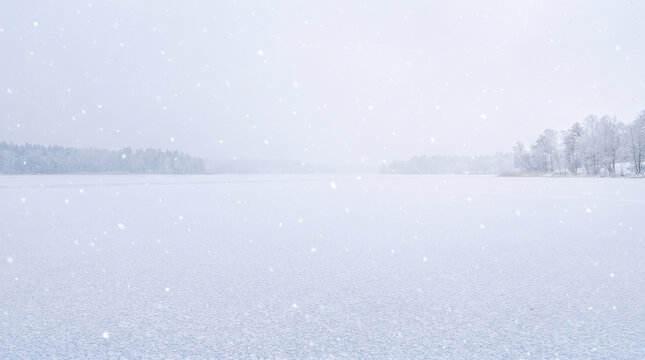 Winter landscape with snow covered fields and distant trees on a hazy day