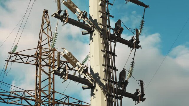 Scenic view of electricity pylons stretching on a street with sky and clouds background.