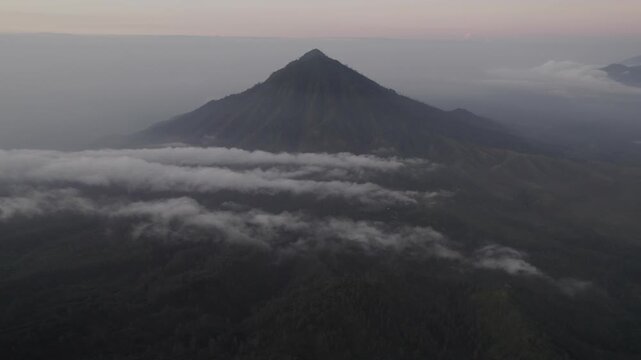 Majestic Volcanic Mountain Peak Emerging from Thick Clouds at Dawn - Aerial Landscape