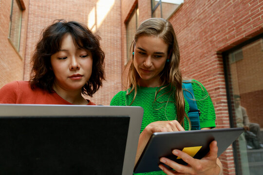 Two Women Look at Tablets Together