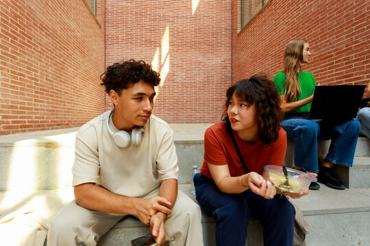 Friends Talking on Steps in a Brick Building