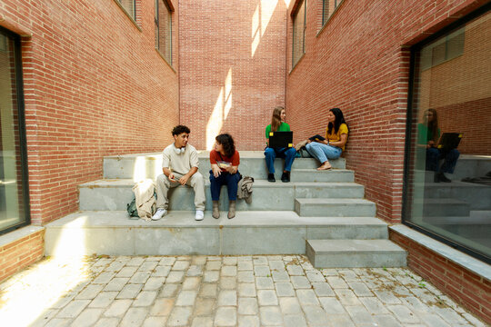 Group of Students Sit on Steps in Urban Space