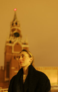 Woman Standing in Front of a Kremlin Clock Tower at Night