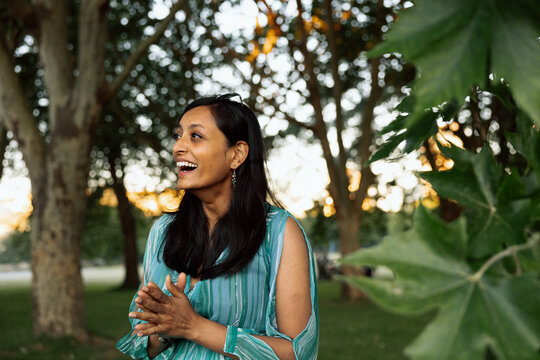 Candid portrait of a joyful woman laughing in a park