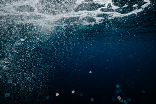 air bubbles drifting through deep blue ocean water