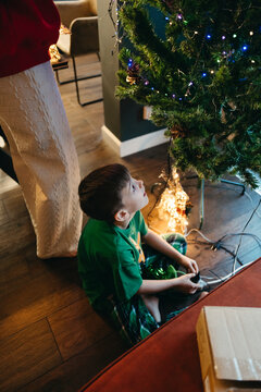Child Enjoys Wonder of Christmas Tree Lights in Cozy Living Room