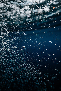 air bubbles rising through deep blue water