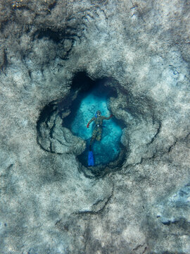 freediver exploring the rocky seabed in clear mediterranean sea