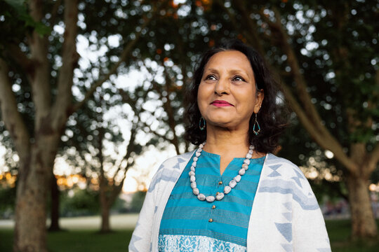 Serene mature South Asian woman portrait outdoors at sunset