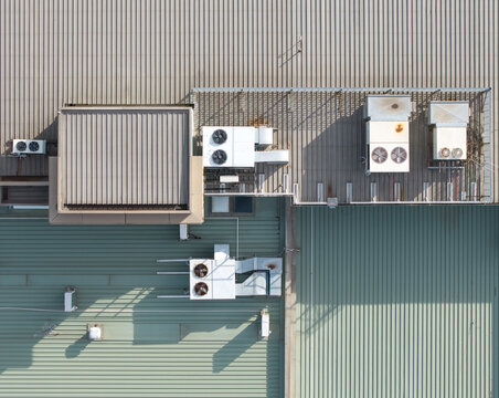 Aerial view of industrial factory rooftops featuring metal corrugated sheets and multiple HVAC ventilation units under bright daylight in Melbourne, VIC, Australia.