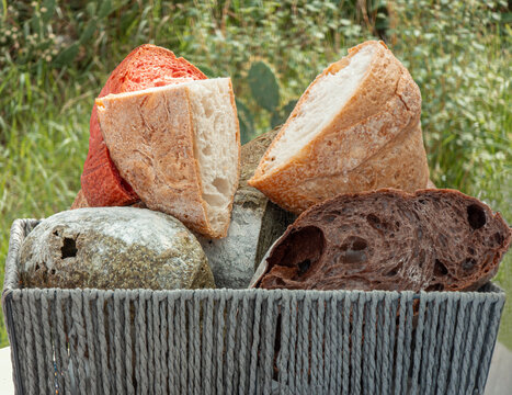 Woven basket filled with artisanal bread loaves in a natural setting