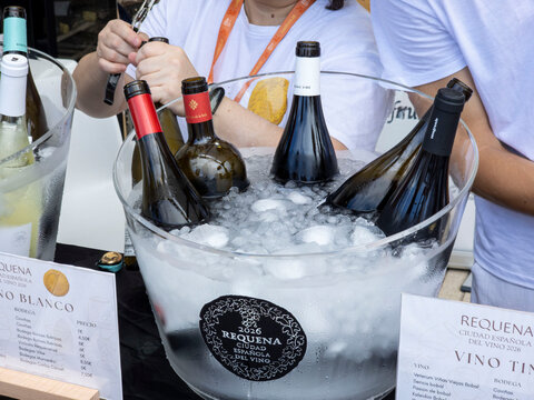 Denia, Spain - September 26, 2026.Bottles of Spanish wine chill in a large ice bucket at an outdoor tasting event in Requena