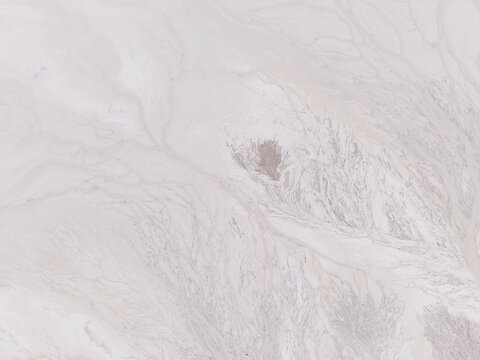 Aerial view of the tailings storage facility featuring intricate light-colored sediment patterns and drainage channels, Padina, Varna, Bulgaria.
