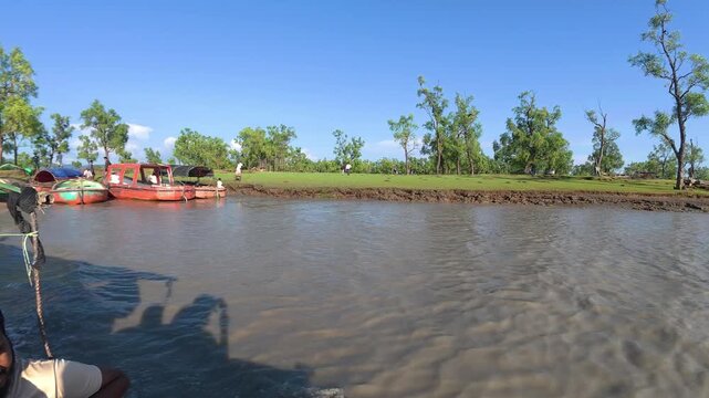CHITTAGONG , BANGLADESH - SEPTEMBER 23, 2026: Engine boat on river water near green bank