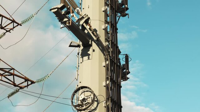 Scenic view of electricity pylons stretching on a street with sky and clouds background.