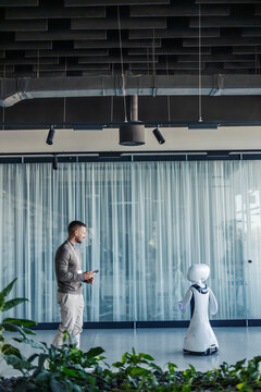 Man interacting with robot in modern office environment