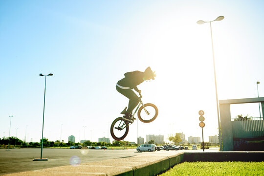 Bicycle, air and man with trick in city with flare, jump or stunt for extreme sports outdoor. Skill, action and person on bike for fitness, cyclist challenge or rider with talent in urban park