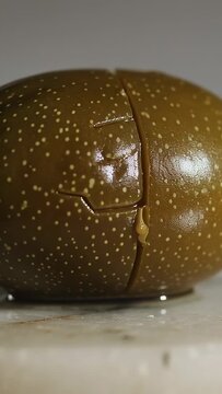 Vertical video: Starting sequence showing speckled green fruit rotating on marble, revealing flesh
