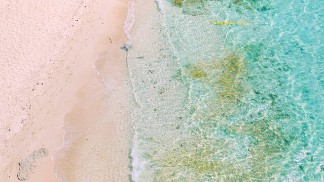 Aerial view of the pristine white sand beach and crystal clear turquoise waters of Boracay Island in Malay, Western Visayas, Philippines.
