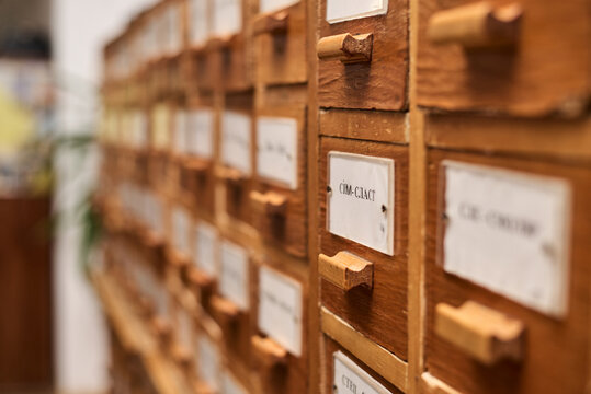 Wooden old fashioned library catalogue with boxes and signs depicting letters in alphabetical order.Studies at the university or college finding paper books and other resources. Writing thesis process