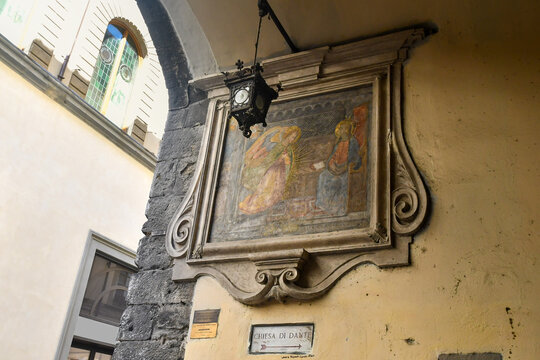 Seventeenth century street shrine tabernacle of Santissima Annunziata copy with a directional sign to the Church of Dante Alighieri, Florence, Tuscany, Italy