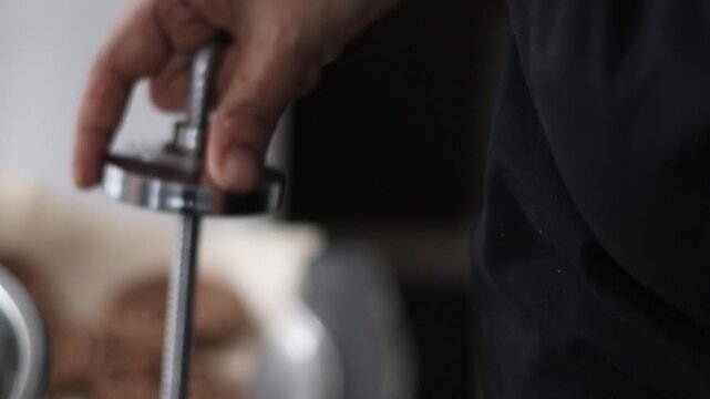 Filling and tightening a murukku mould with ragi dough for a traditional Indian snack