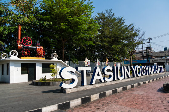 Yogyakarta, Indonesia - August 30, 2026: Large sign text Stasiun Yogyakarta with vintage steam roller replica monument at Yogyakarta Station.