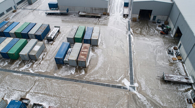 Aerial view of industrial site with scattered metal cargo container in factory, calm and quiet atmosphere, logistics supply chain