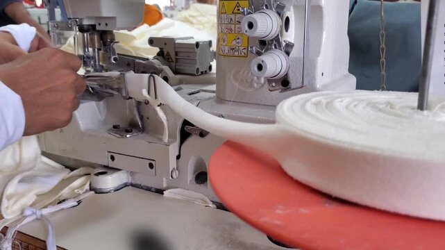 Textile industry industrial overlock machine stitching garment tape in apparel factory
