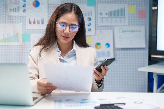 Businesswoman Analyzing Financial Documents and Investment Data