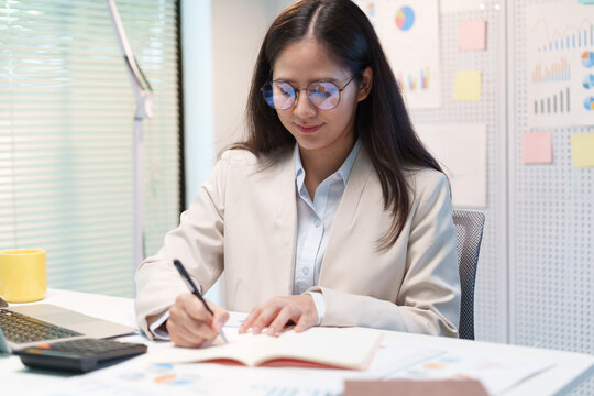 Businesswoman Analyzing Financial Documents in Office