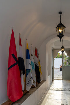 Historical 1821 Greek revolutionary flags display in arched corridor on Spetses Island, Greece