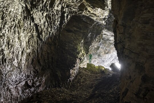 Hiker explores Obstans ice cave in Alta Pusteria, Carnic Alps, East Tyrol, Austria
